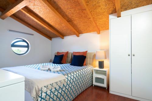 a bedroom with a bed with blue and orange pillows at Host Wise - Impressive Restful Houses in Porto