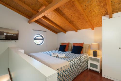 a bedroom with a bed with blue and orange pillows at Host Wise - Impressive Restful Houses in Porto