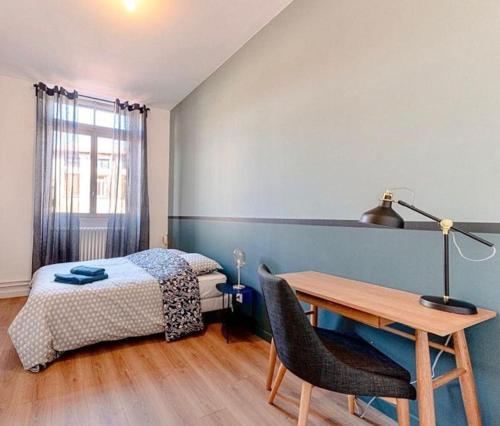 une chambre avec un lit, un bureau et une table dans l'établissement L'horizon, à Saint-Étienne