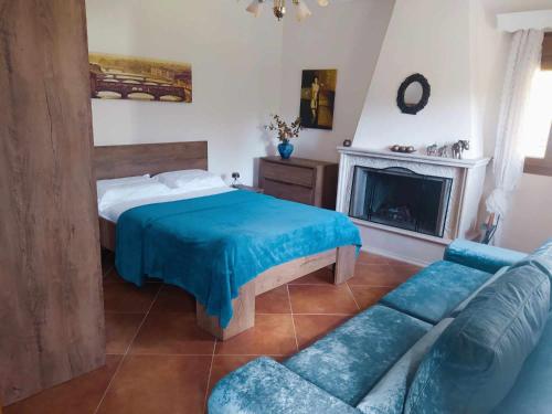 a bedroom with a bed and a couch and a fireplace at Garden House KRISTI in Possidi