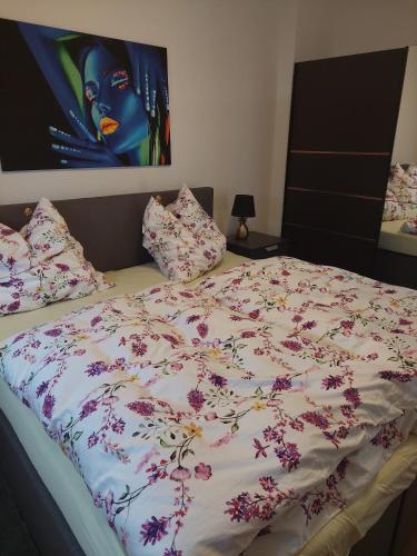 Una cama con una manta con flores. en Tapas restaurante 1 en Viersen