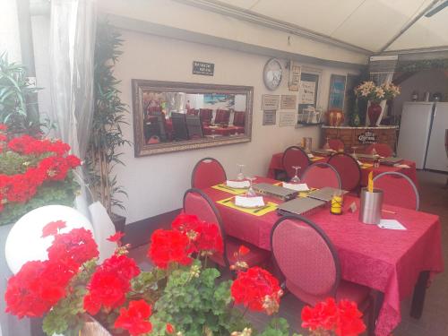 a meeting room with a table and red flowers at Tapas restaurante 1 in Viersen