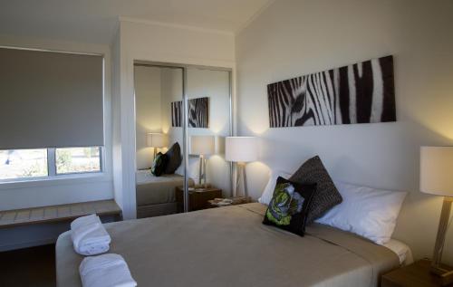 1 dormitorio con cama y ventana grande en Savannah Cabins, Taronga Western Plains Zoo, en Dubbo