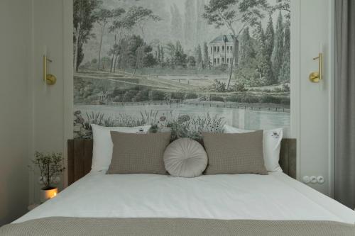 a bedroom with a white bed with a painting on the wall at Willa Szwarc by Elite Apartments in Sopot