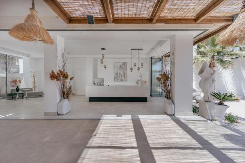 a living room with white walls and a wooden ceiling at Galazio Beach Resort by Estia in Hersonissos