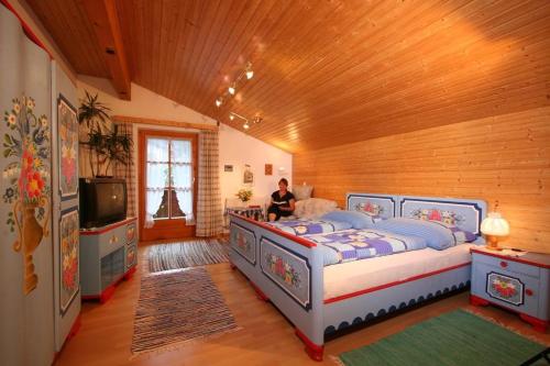 a woman in a bedroom with a bed and a tv at Ferienwohnung Amann in Vandans