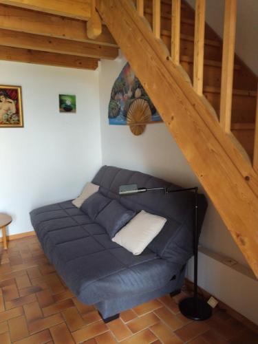 uma cama no canto de um quarto debaixo de uma escada em Résidence Marina Soleil Bleu em Le Barcarès