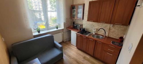 a small kitchen with a couch and a sink at Apartament Skwer Kosciuszki Morze in Gdynia