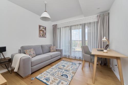 een woonkamer met een bank en een tafel bij Walońska 16 Sauna & Fitness Family Apartments by Renters Prestige in Wrocław