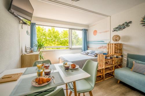 Una habitación con una cama y una mesa con comida encima. en L'Escale de la Plage, en Gruissan