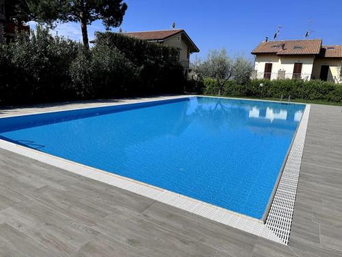 une grande piscine bleue en face d'une maison dans l'établissement Gioia Home, à Bardolino