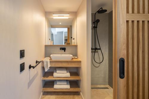 ein Bad mit einem Waschbecken und einem Spiegel in der Unterkunft Hôtel L'Escalet in Ramatuelle
