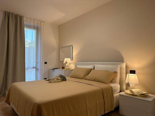 - une chambre avec un grand lit et une fenêtre dans l'établissement Gioia Home, à Bardolino