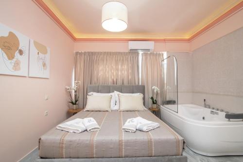 una camera con letto e vasca da bagno, un letto e una vasca da bagno di Ex Animo - Luxury Apartments a Città di Zante