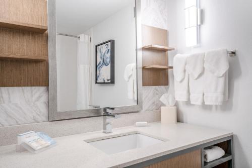 a bathroom with a sink and a mirror and towels at Hilton Garden Inn Pittsburgh/Southpointe in Canonsburg