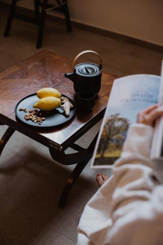 a table with a plate of food and a book at Ansitz Montani Eppan in Appiano sulla Strada del Vino