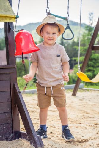 a young boy wearing a hat on a playground at Srebrny Bucznik Wellness & Restaurant in Istebna