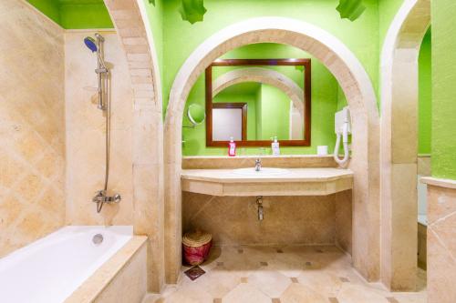 ein Badezimmer mit einem Waschbecken, einer Badewanne und einem Spiegel in der Unterkunft Ghazala Gardens in Sharm El Sheikh