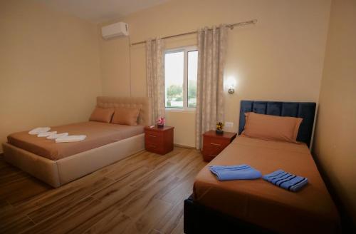 a room with two beds and a window with at Hanna & Solei Hotel in Berat