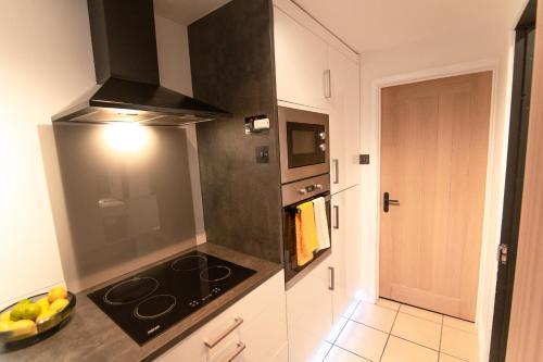 a kitchen with a stove and a counter top at Luxury Bumblebee Cottage Frome Longleat Aqua Sana Bath DOG FREEndly in Frome
