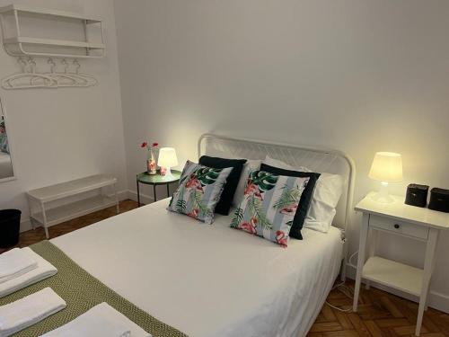 a bedroom with a white bed with two pillows on it at Alvalade II Airport Guest House in Lisbon