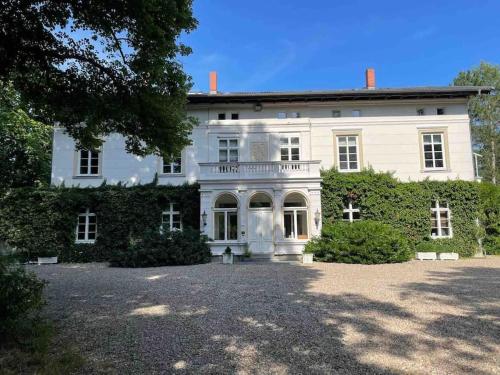 a large white house with a large yard at Grosses 2 Zi-DG in grüner Idylle! in Bliestorf