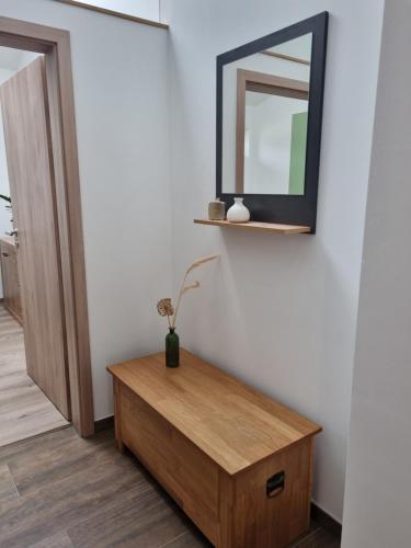 a mirror on a wall next to a wooden table at Eiselehof Ferienwohnungen in Alleinlage in Rot am See