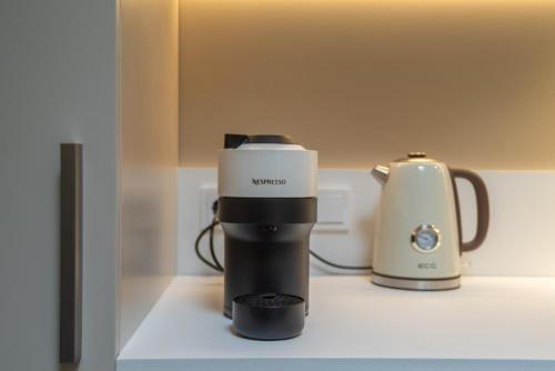 a coffee maker on a counter next to a blender at Apartamentai Astra in Druskininkai