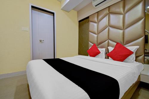 a bedroom with a large bed with red pillows at Hotel Snowfox in Madhyamgram