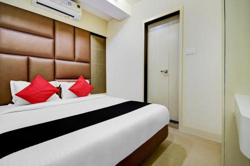 a bedroom with a large bed with red pillows at Hotel Snowfox in Madhyamgram