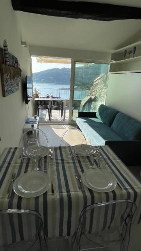 una camera con un tavolo, due sedie e un letto di Seafront rooftop flat w/ terrace a Portovenere