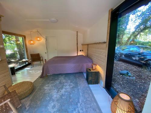 ein Schlafzimmer mit einem Bett und ein Auto außerhalb eines Fensters in der Unterkunft Sommerhus med sjæl in Egå