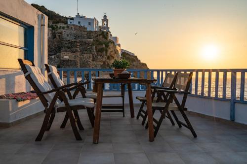 stół i krzesła na balkonie z widokiem na ocean w obiekcie Imerios Nisyrian House w mieście Mandrákion