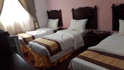 فندق روابي العزيزية-Rawaby Hotels في مكة المكرمة: غرفه فندقيه ثلاث اسره ونافذه