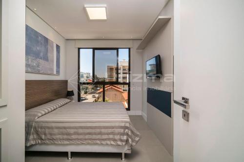 Schlafzimmer mit einem Bett und Stadtblick in der Unterkunft SD 202 · Excelente Apartamento em condomínio com Rooftop e Piscina. in Bombinhas