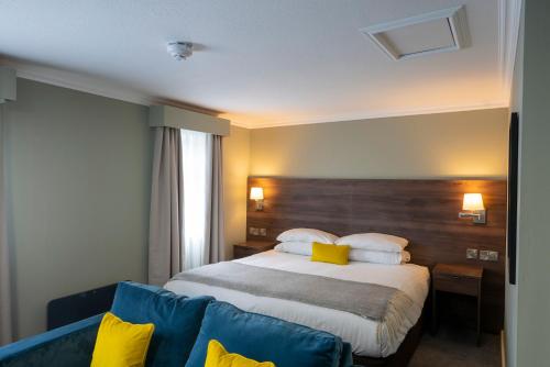 a hotel room with a bed and a blue couch at Beaufort Park Hotel in Mold