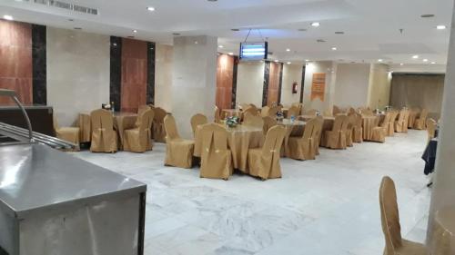 فندق روابي العزيزية-Rawaby Hotels في مكة المكرمة: قاعة احتفالات مع طاولات وكراسي في غرفة