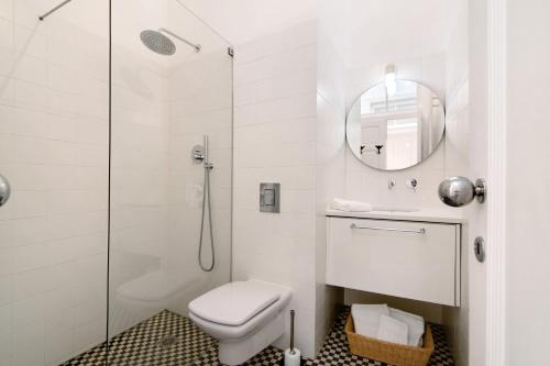 a white bathroom with a shower and a toilet at Casa Rosa in São Brás de Alportel