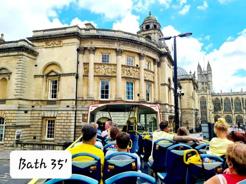 a group of people riding on a tram in front of a building at Luxury Bumblebee Cottage Frome Longleat Aqua Sana Bath DOG FREEndly in Frome