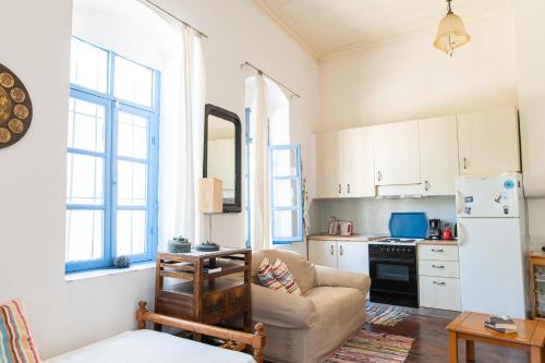 a living room with a couch and a kitchen at Imerios Nisyrian House in Mandrákion