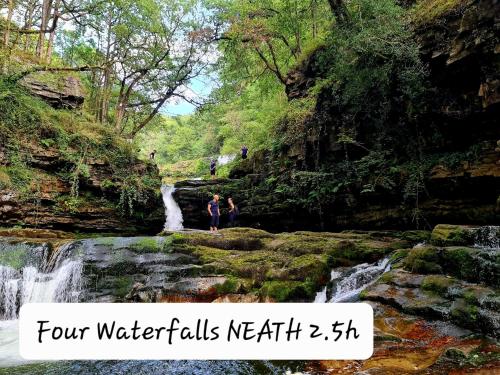 a woman standing in front of a waterfall at Luxury Bumblebee Cottage Frome Longleat Aqua Sana Bath DOG FREEndly in Frome