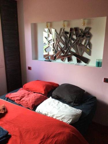 - une chambre avec 2 lits dotés d'oreillers rouges et blancs dans l'établissement Proche de Paris 25minTout équipé, 2 chambres, à Conflans-Sainte-Honorine