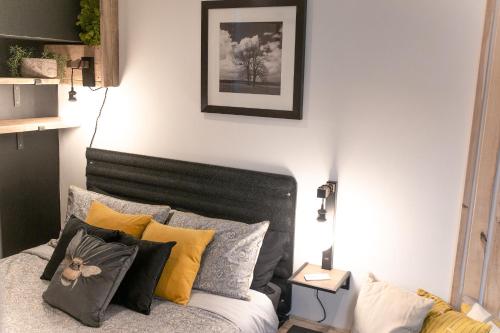 a bedroom with a bed with many pillows on it at Luxury Bumblebee Cottage Frome Longleat Aqua Sana Bath DOG FREEndly in Frome