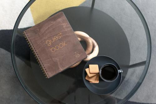 a book and a cup of coffee on a glass table at Luxury Bumblebee Cottage Frome Longleat Aqua Sana Bath DOG FREEndly in Frome