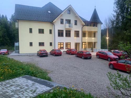 un grupo de coches estacionados frente a un edificio en Penzión Probstner en Nová ľubovňa