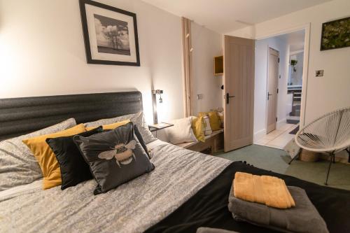 Un dormitorio con una cama grande con almohadas. en Luxury Bumblebee Cottage Frome Longleat Aqua Sana Bath DOG FREEndly, en Frome