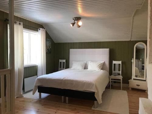 1 dormitorio con 1 cama blanca grande y paredes verdes en Little Red School House, en Töfsala