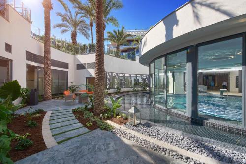 une maison avec une piscine et des palmiers dans l'établissement First Cap - Luxury 1BR with terrace in the most prestigious development of the French Riviera, à Antibes