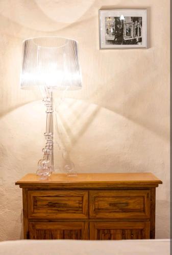 a table with a lamp on top of a dresser at PienzaLettings "Casa Olivieri" in Pienza