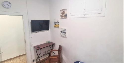Pokój ze stołem i telewizorem na ścianie w obiekcie Habitacion en centro de ciudad con baño compartido w Pampelunie